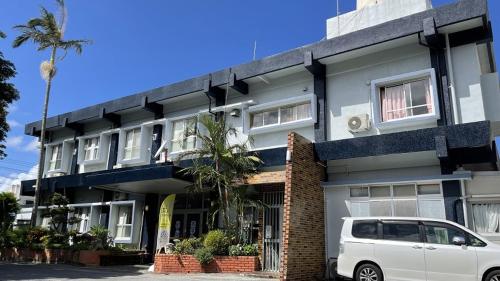 a white van parked in front of a building at Hotel Harbor in Agena