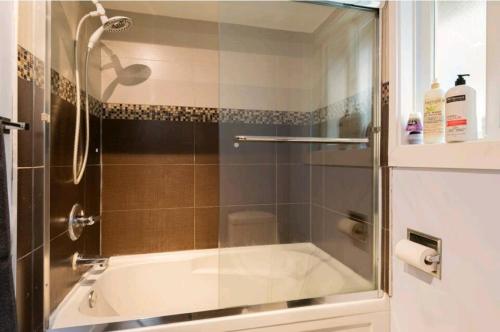 a bathroom with a shower and a bath tub at CHEERFuL 2 LEVEL HOUSE 4 BED 3 BATH PARKiNG in Delta