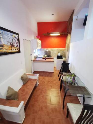 a living room with a table and a kitchen at Bonito departamento con alberca en Cancún in Cancún