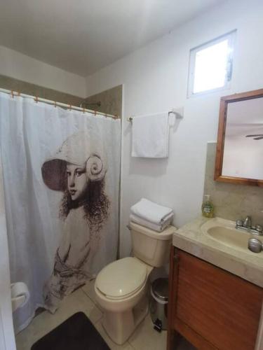 a bathroom with a shower curtain with a picture of a woman at Bonito departamento con alberca en Cancún in Cancún