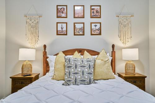 a bedroom with a bed with two lamps and pictures on the wall at Gym❂Conference Room❂Desk ❂Mtn/Pool View in Salt Lake City