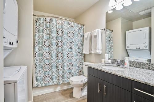 a bathroom with a toilet and a shower curtain at Gym❂Conference Room❂Desk ❂Mtn/Pool View in Salt Lake City