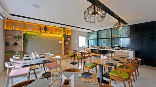 a restaurant with tables and chairs and a chalkboard at Click Hotel Biz, Bangalore International Airport in Yelahanka