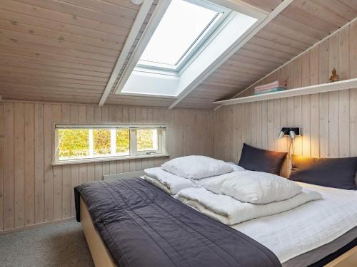 a bedroom with a large bed with a skylight at Three-Bedroom Holiday home in Hemmet 30 in Humble