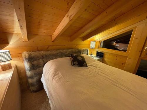 a bedroom with a bed in a wooden cabin at Chalet Les Carroz d'Arâches, 5 pièces, 8 personnes - FR-1-572-32 in Arâches-la-Frasse