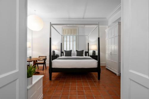 Un dormitorio con una cama y una mesa. en Bella Nara Hotel Chiang Mai en Chiang Mai