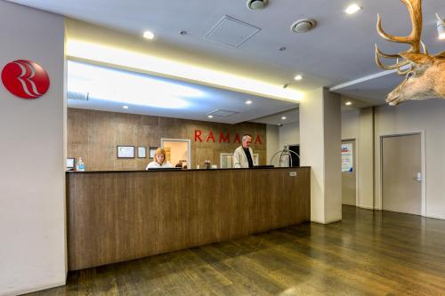 a hotel reception desk with a deer head on the wall at Ramada Suites by Wyndham Queenstown Remarkables Park in Queenstown