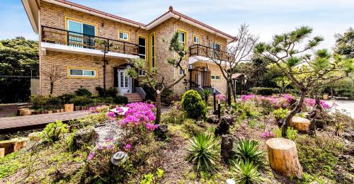 een huis met bloemen ervoor bij Eco Resort in Seogwipo