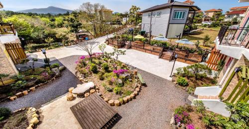 Una vista aérea de un jardín con un banco y flores. en Eco Resort, en Seogwipo