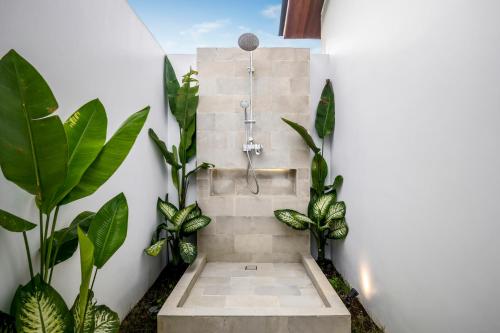 y baño con ducha con plantas. en Villa Hammock by BaliSuperHost, en Ubud