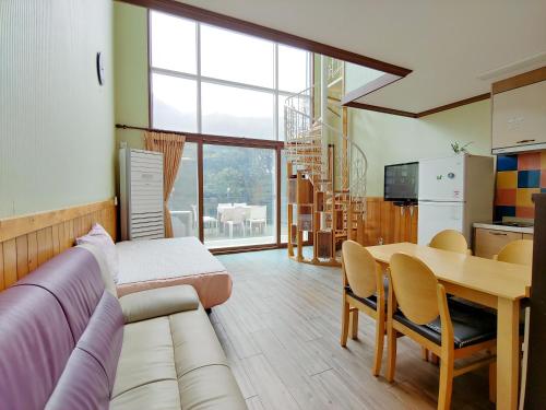 a living room with a couch and a table at Eco Resort in Seogwipo