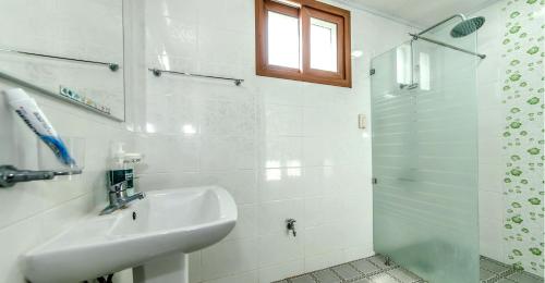 bagno bianco con lavandino e doccia di Eco Resort a Seogwipo