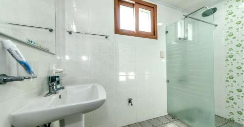 une salle de bain blanche avec un lavabo et une douche dans l'établissement Eco Resort, à Seogwipo