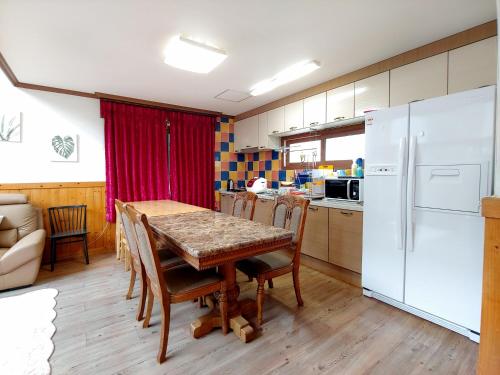 een keuken met een tafel en een witte koelkast bij Eco Resort in Seogwipo