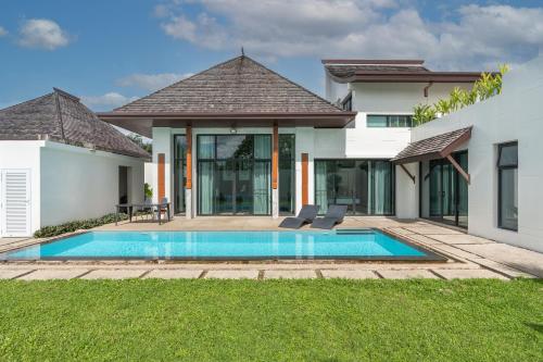 a house with a swimming pool in the yard at Beautiful 3 bedroom pool villa with 65inch smart tv Located near popular Bangtao beach and laguna Phuket in Bang Tao Beach