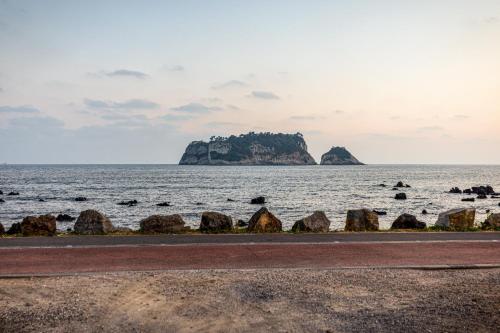 a view of the ocean with rocks in the foreground at Euro House in Seogwipo