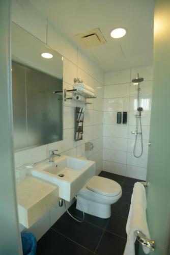 a white bathroom with a sink and a toilet at Manhattan Business Hotel TTDI in Petaling Jaya