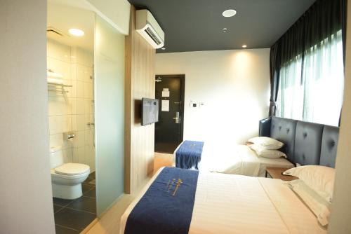 a bathroom with a bed and a toilet in a room at Manhattan Business Hotel TTDI in Petaling Jaya