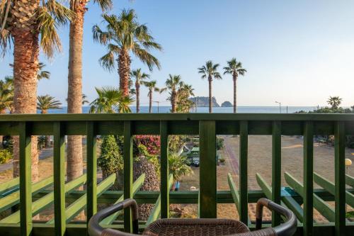 a balcony with palm trees and a beach at Euro House in Seogwipo