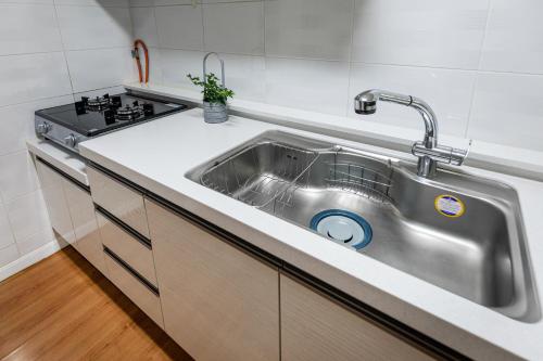 a stainless steel sink in a kitchen next to a stove at Euro House in Seogwipo