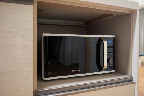 a microwave in a cabinet in a kitchen at Euro House in Seogwipo