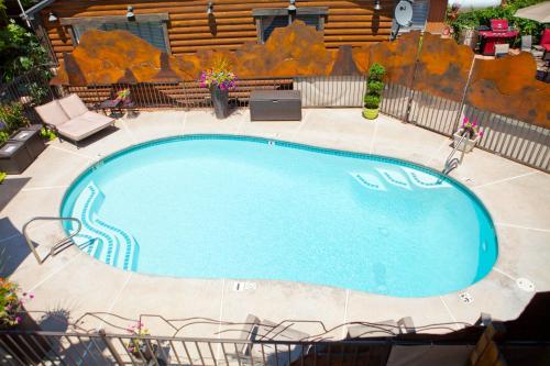 a large swimming pool in a yard with chairs around it at Canyons Boutique Hotel - A Canyons Collection Property in Kanab