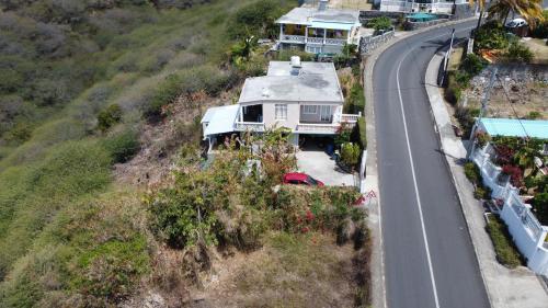 a house on a hill next to a road at Eagles Nest Residence in Rodrigues Island