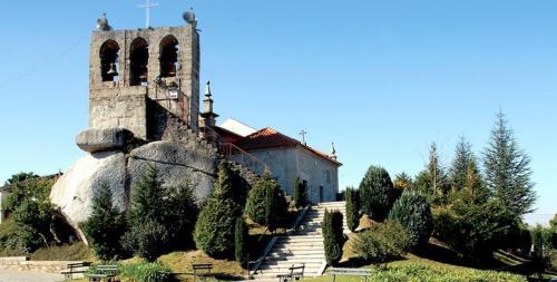 a church with a tower and stairs leading to a building at Casa de Campo Sossego da Lata in Fafe