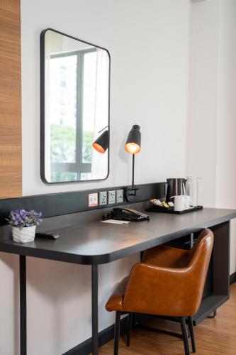 a desk with a mirror and a chair at Travelodge Ipoh in Ipoh