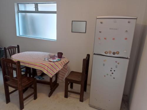 ein Esszimmer mit einem Tisch und einem Kühlschrank in der Unterkunft FER'S HOUSE in Lima