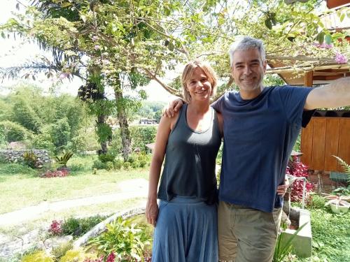 a man and a woman standing in a garden at NUANSA HOMESTAY Authentic&Hospitality in Rantepao