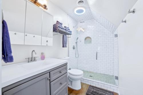 a white bathroom with a toilet and a shower at Close to St. Francis Hospital • 4 Smart Tvs • Pool • Patio in Tulsa