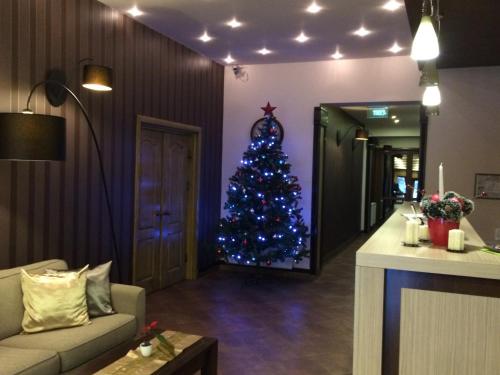a christmas tree in a living room with a couch at Pensiunea Lido in Piatra Neamţ