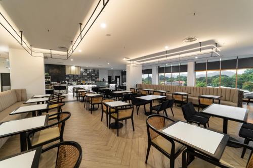 a dining room with tables and chairs and windows at Travelodge Ipoh in Ipoh