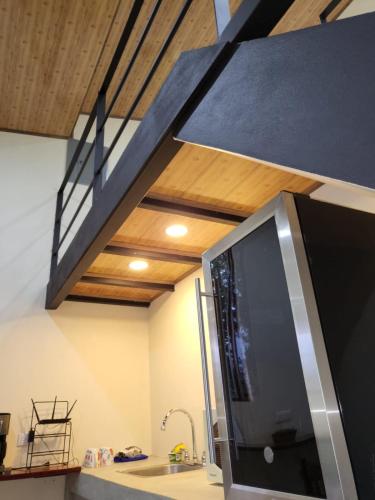 a kitchen with a microwave oven and a staircase at Modern Loft inside a beautiful farm in General Viejo