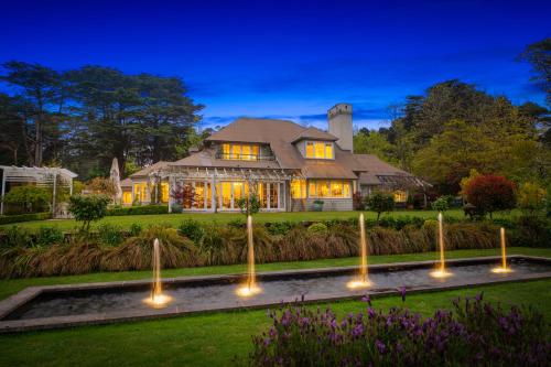 una casa con una fuente frente a una casa en Parklands Country Gardens & Lodges Blue Mountains en Blackheath