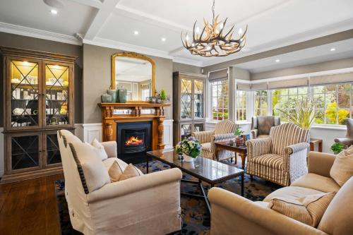 a living room with chairs and a fireplace at Parklands Country Gardens & Lodges Blue Mountains in Blackheath