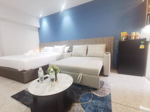 曼谷的住宿－ABC@48 Hotel & Service Apartment，客房设有两张床、一张沙发和一张桌子。