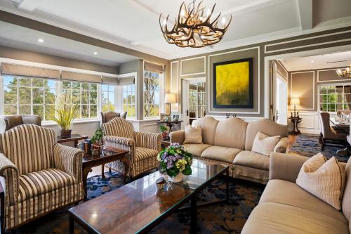 a living room with couches and a table at Parklands Country Gardens & Lodges Blue Mountains in Blackheath