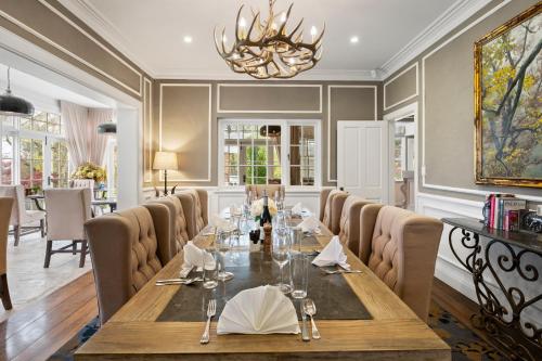 a dining room with a long table and chairs at Parklands Country Gardens & Lodges Blue Mountains in Blackheath