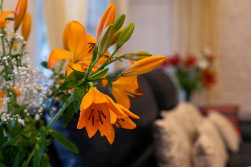 a group of orange flowers in a vase at StayVista at Aashirwaad Villa in Coonoor