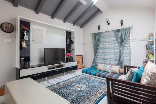 a living room with a couch and a tv at StayVista at Aashirwaad Villa in Coonoor