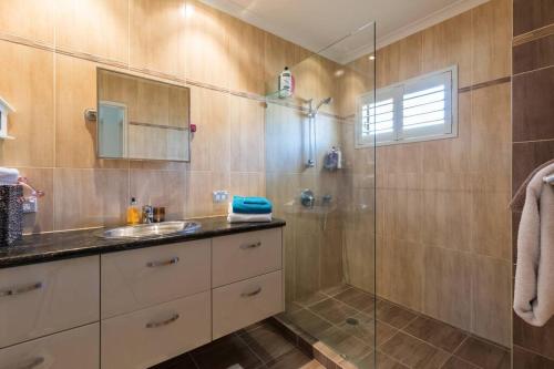 uma casa de banho com um lavatório e uma cabina de duche em vidro. em Beachfront MIAMI 2 Bdr Easy Living VIEWS VIEWS!!!! em Gold Coast