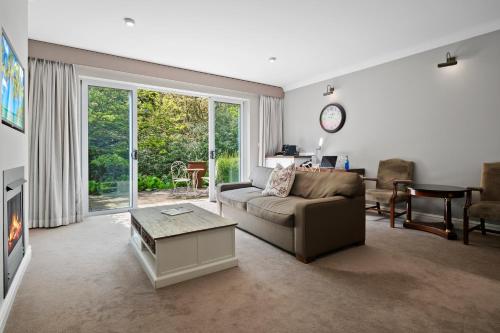a living room with a couch and a table at Parklands Country Gardens & Lodges Blue Mountains in Blackheath