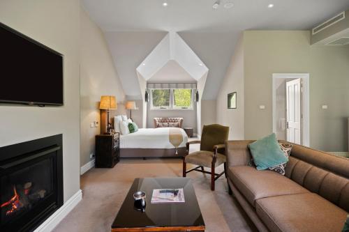 a living room with a couch and a bed at Parklands Country Gardens & Lodges Blue Mountains in Blackheath