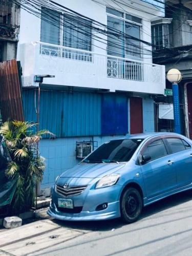 a blue car parked in front of a building at THE MANSION - 2 PAX SOLO BUDGET Room near AIRPORT TERMINAL in Manila