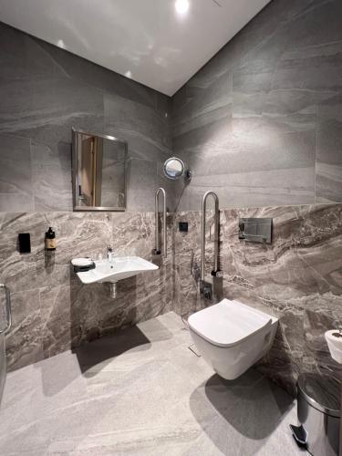 a bathroom with a white toilet and a sink at Wyndham Garden Baku in Baku