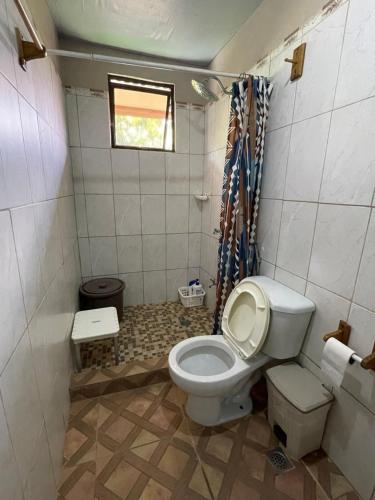 a small bathroom with a toilet and a window at West Sahara Beach House in Cabangan