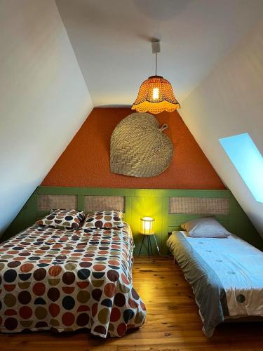 une chambre mansardée avec un lit et un plafond dans l'établissement Maison charmante à Maleville avec jardin privé et parking.B, à Maleville