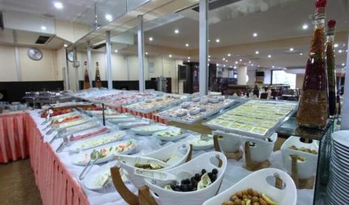 ein langer Tisch mit vielen Teller Essen drauf in der Unterkunft STAYCITY OTEL in Altındağ